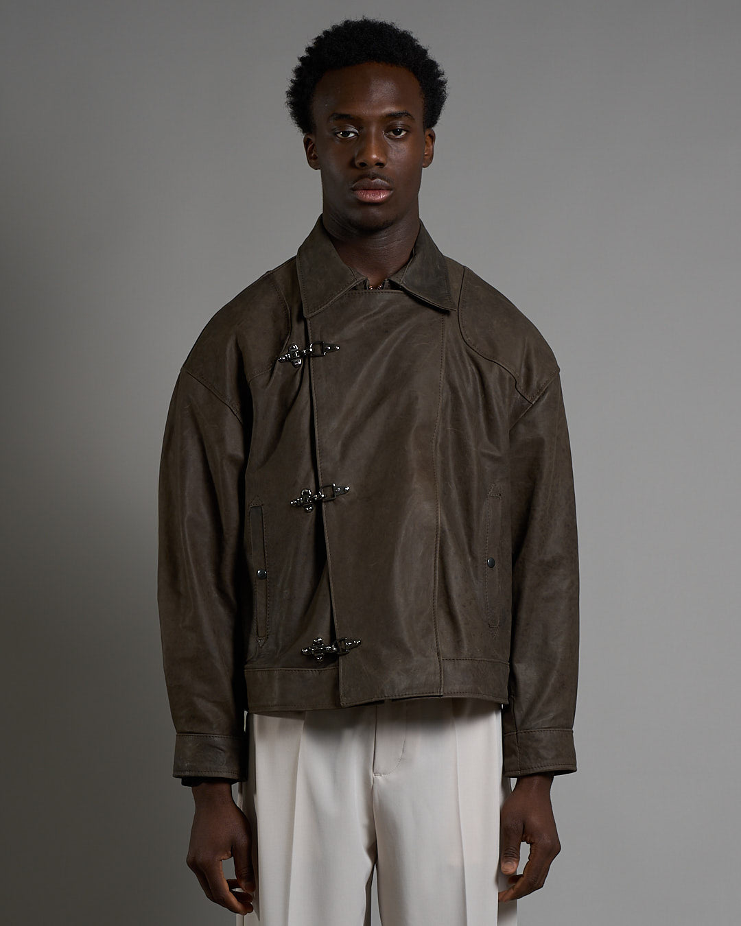 Giacca in pelle cropped con chiusure a scatto